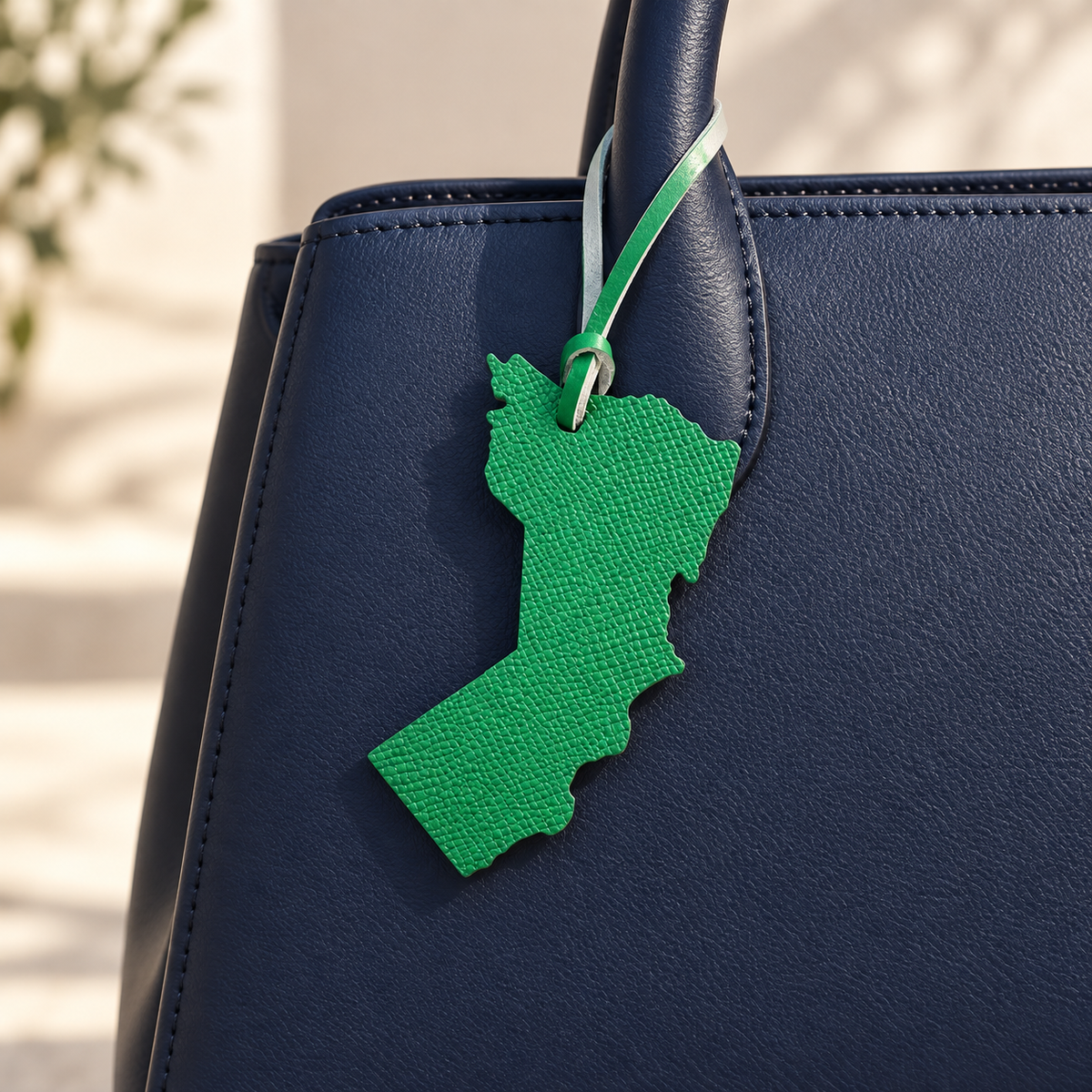 Oman Map Bag Charm styled on a bag (AI-generated)