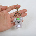 One gray crochet koala charm with a green accent from the set of five