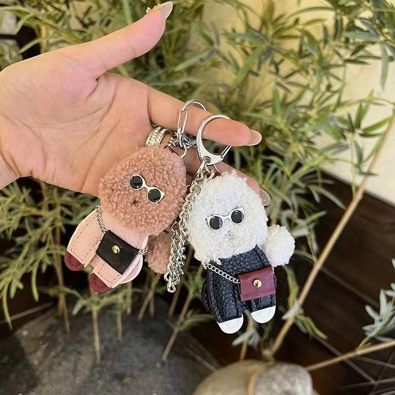 White option is the right-hand white dog in a black outfit with round glasses, white shoe tips and a burgundy miniature bag. Includes one selected charm; pink dog is a separate option.