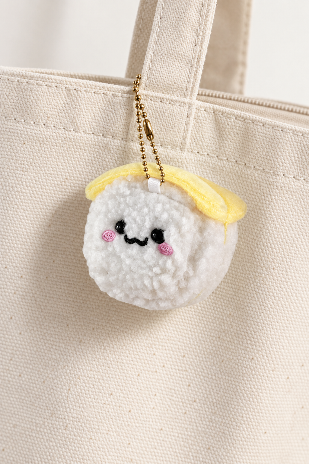 Smiling Plush Sushi Bag Charm styled on a cream tote; bag not included