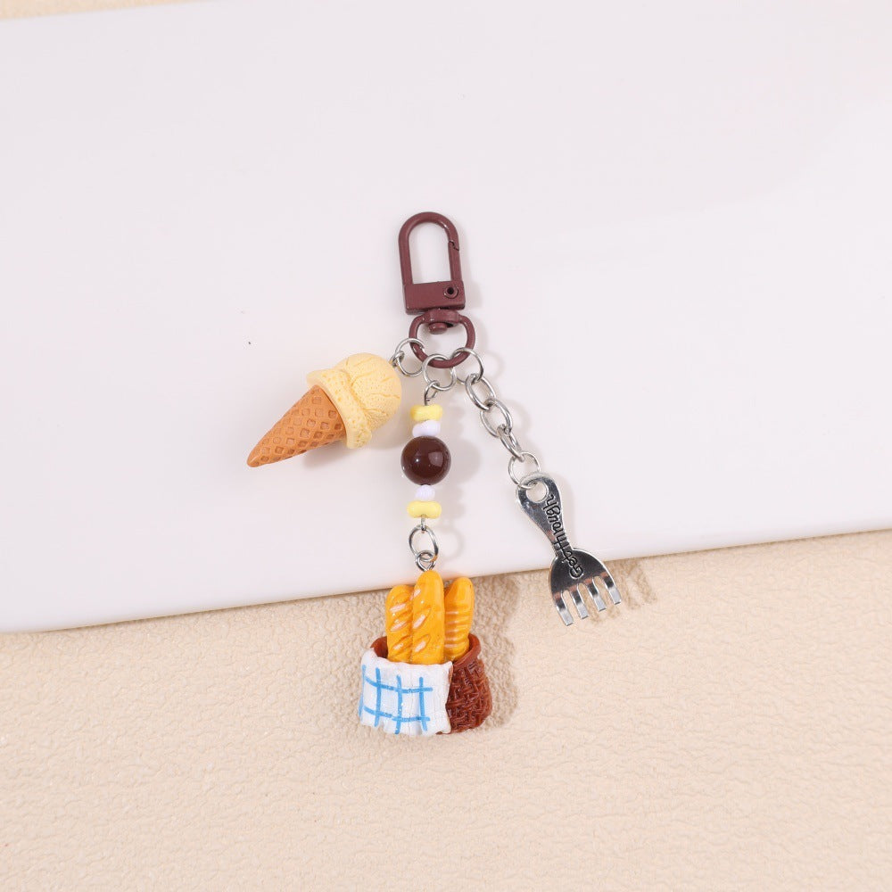 Ice cream and baguette basket bag charm with blue-and-white cloth detail; supplier product photo