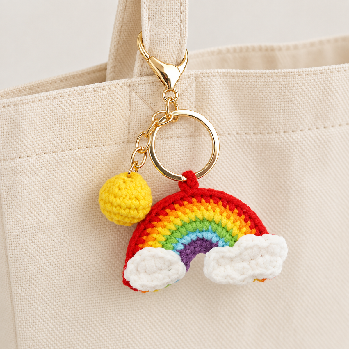 Bright crochet rainbow and clouds charm on a cream bag; bag not included