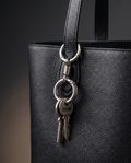 Silver detachable double-loop key holder clipped to a black tote strap