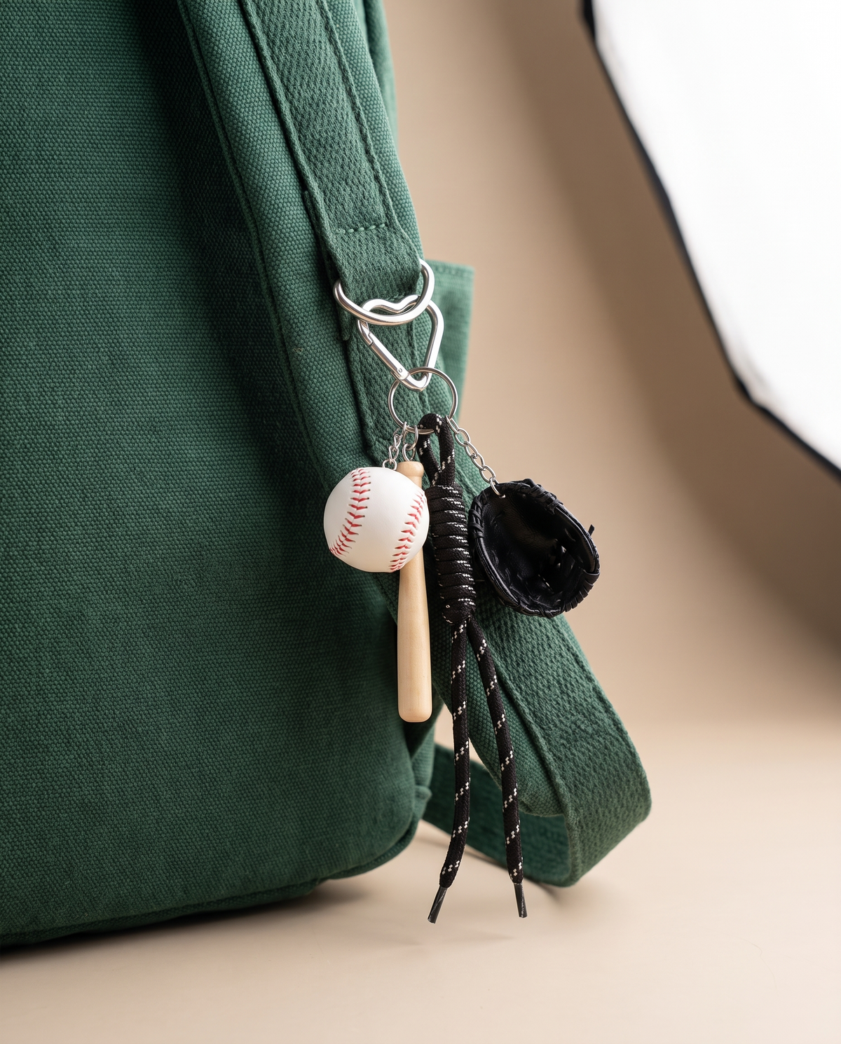 Sporty mini baseball rope charm on a deep green backpack