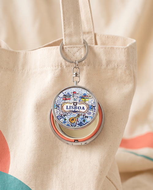 City mini mirror pocket case charm attached to a cream canvas tote