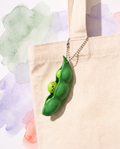 Edamame squeeze pod charm clipped to a beige everyday tote