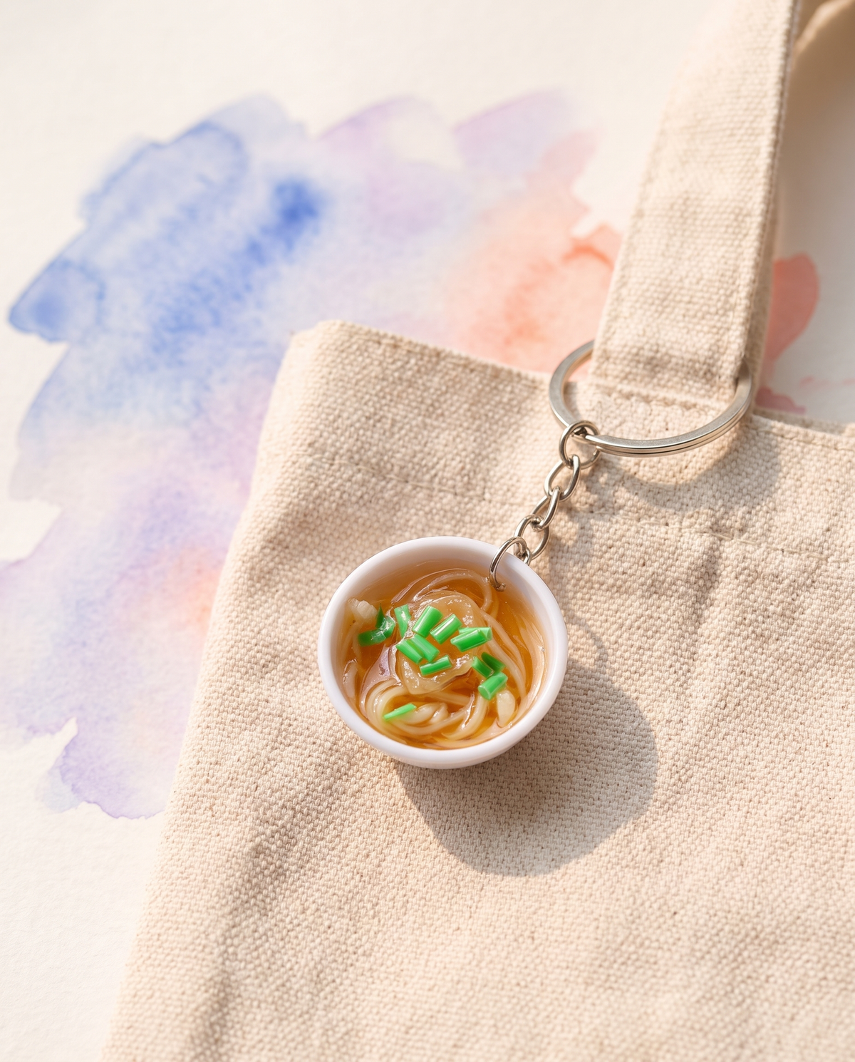 Blue and white noodle bowl charm clipped to an oatmeal tote