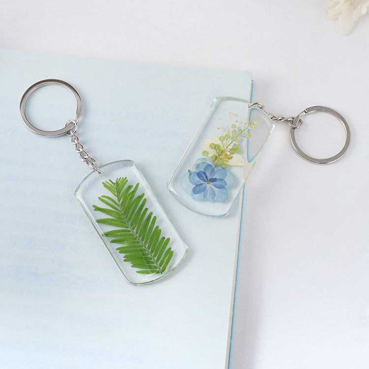 Two pressed botanical designs with silver-tone keyrings
