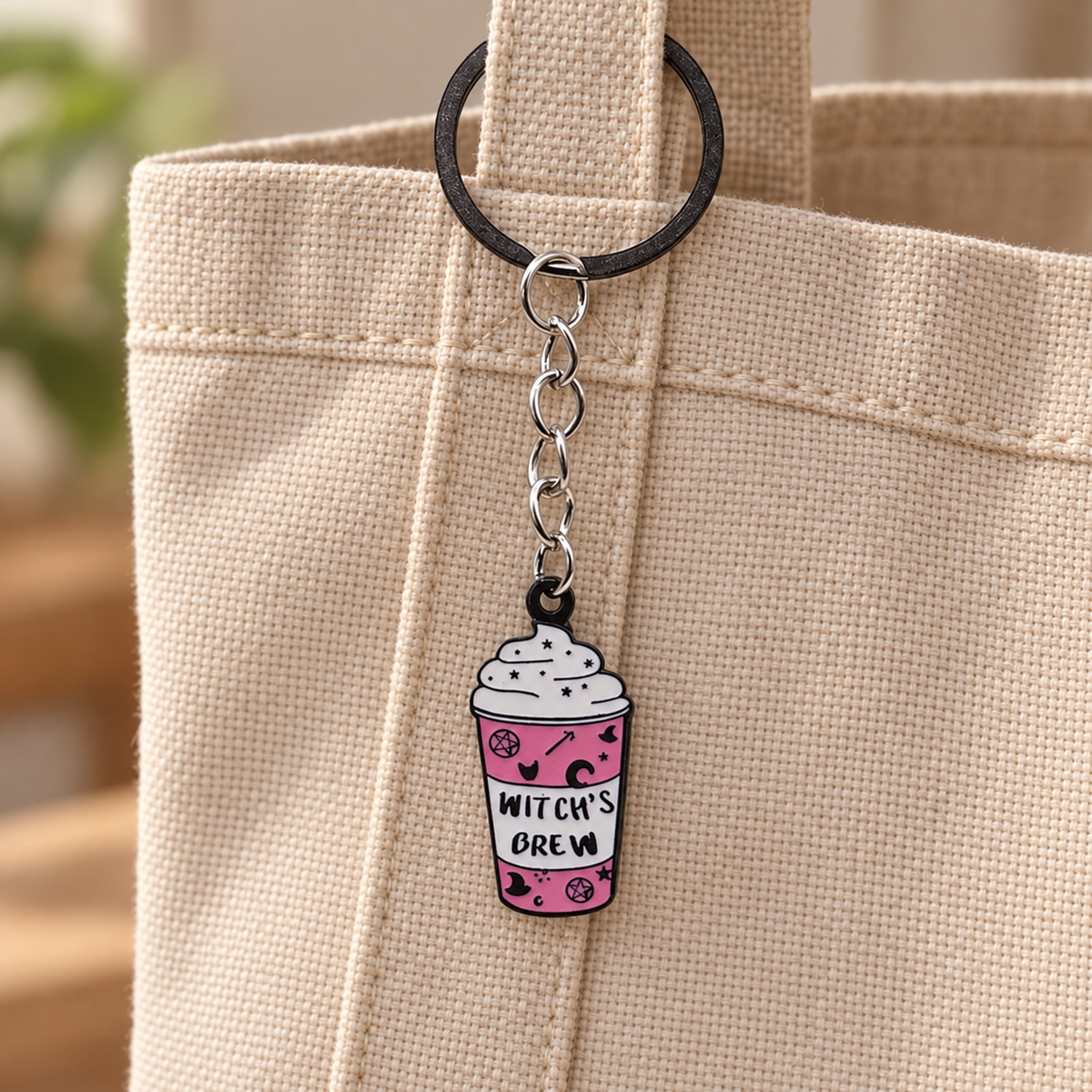 Witch's Brew Cup illustrated bag charm attached to a handbag