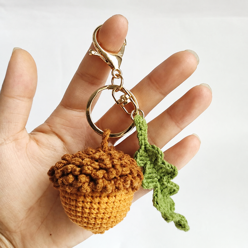 Detail of the crochet acorn, green oak leaf and gold-tone clasp; AI-restored styling photo