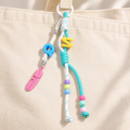 Mint & pink bag charm attached to a canvas bag; bag not included