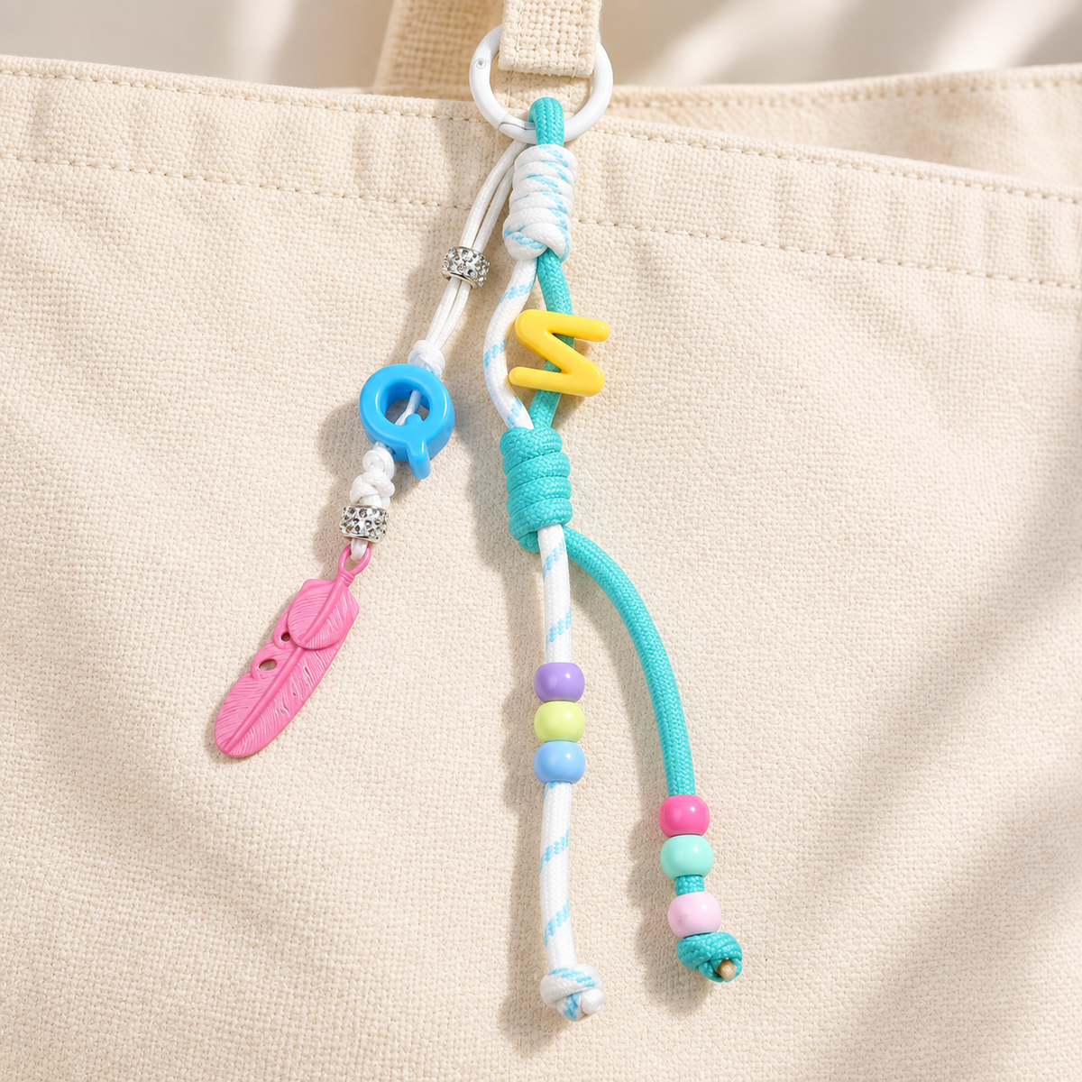 Mint & pink bag charm attached to a canvas bag; bag not included