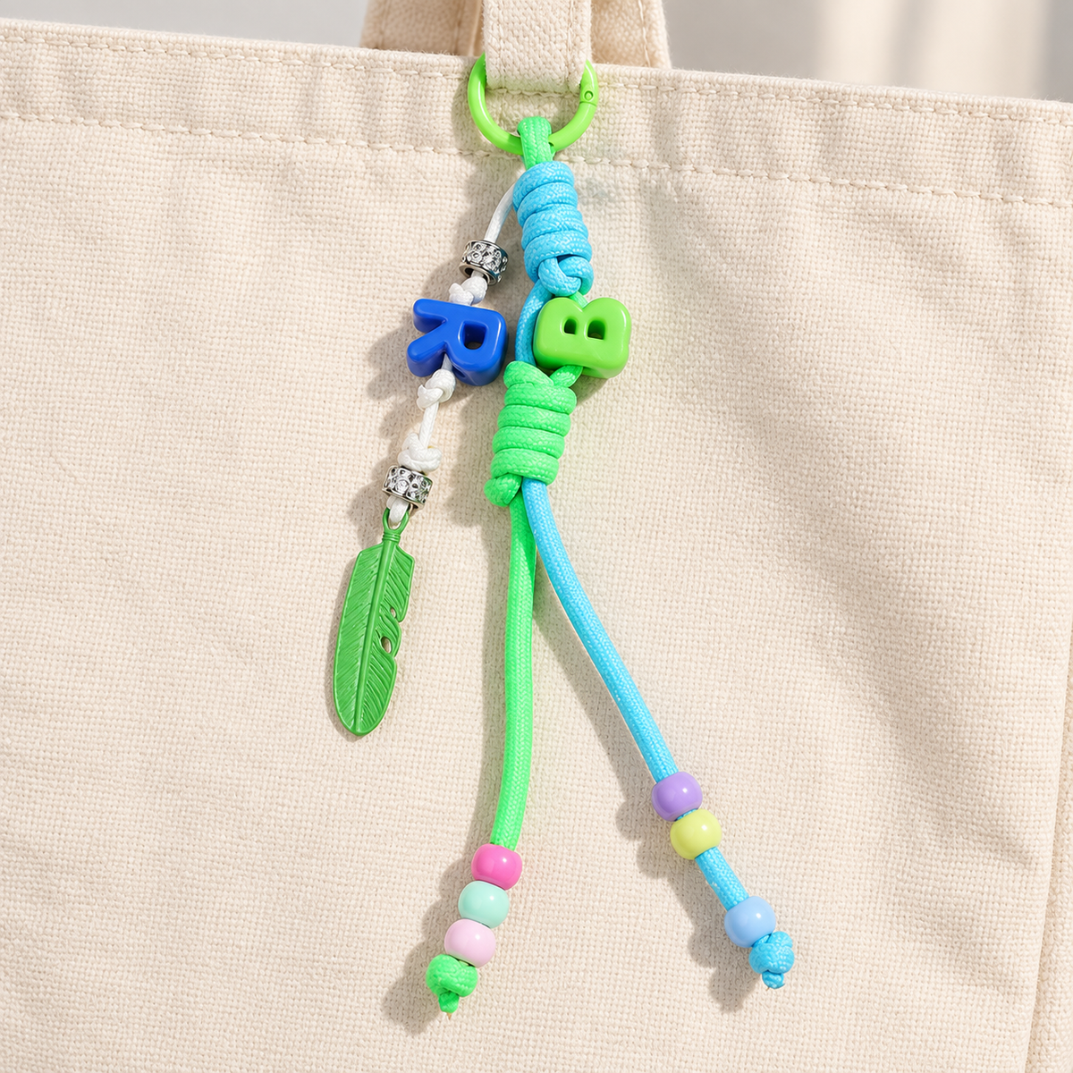 Green & blue bag charm attached to a canvas bag; bag not included
