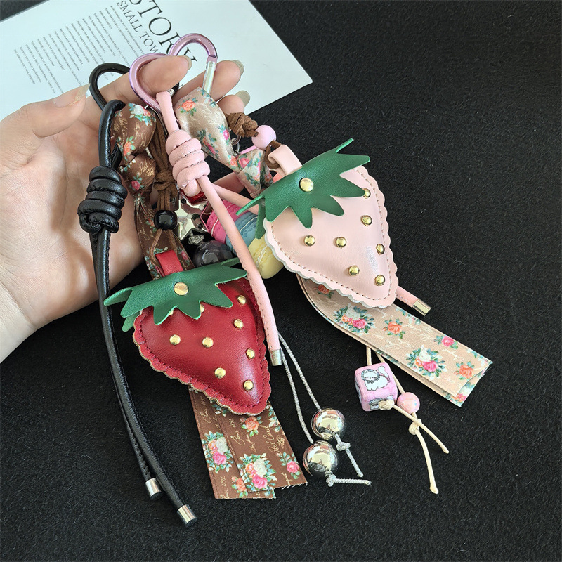 Close view of stitched strawberry, floral ribbon, beads and heart clips; one selected-color charm per item