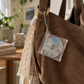 Mini acrylic CD memory bag charm attached to a shoulder bag