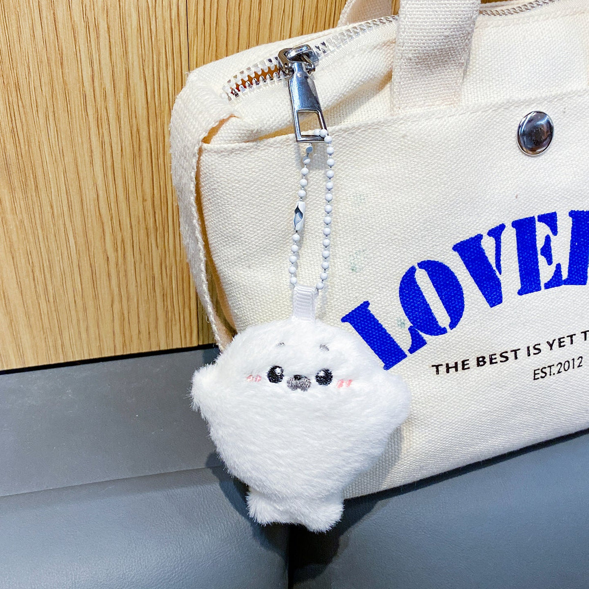 White seal plush charm on a canvas bag