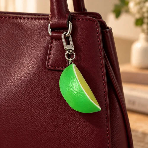 Green Citrus Slice Bag Charm styled on a handbag