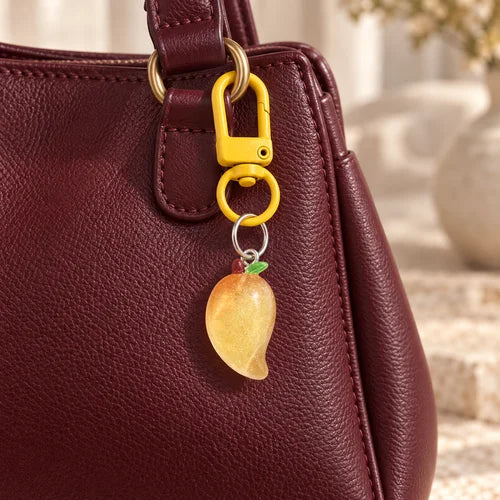 Golden Fruit Charm Pair styled on a handbag